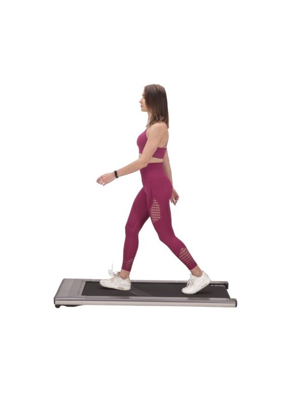Femme en tenue de sport utilisant un tapis de marche compact, parfait pour un entraînement à domicile. Ce tapis de marche est idéal pour maintenir une routine d'exercice régulière, tout en optimisant l'espace et le confort.