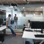 Espace de travail moderne et collaboratif avec une équipe en pleine discussion. Ce bureau ouvert favorise les échanges et la collaboration, créant un environnement dynamique et propice à l'innovation.