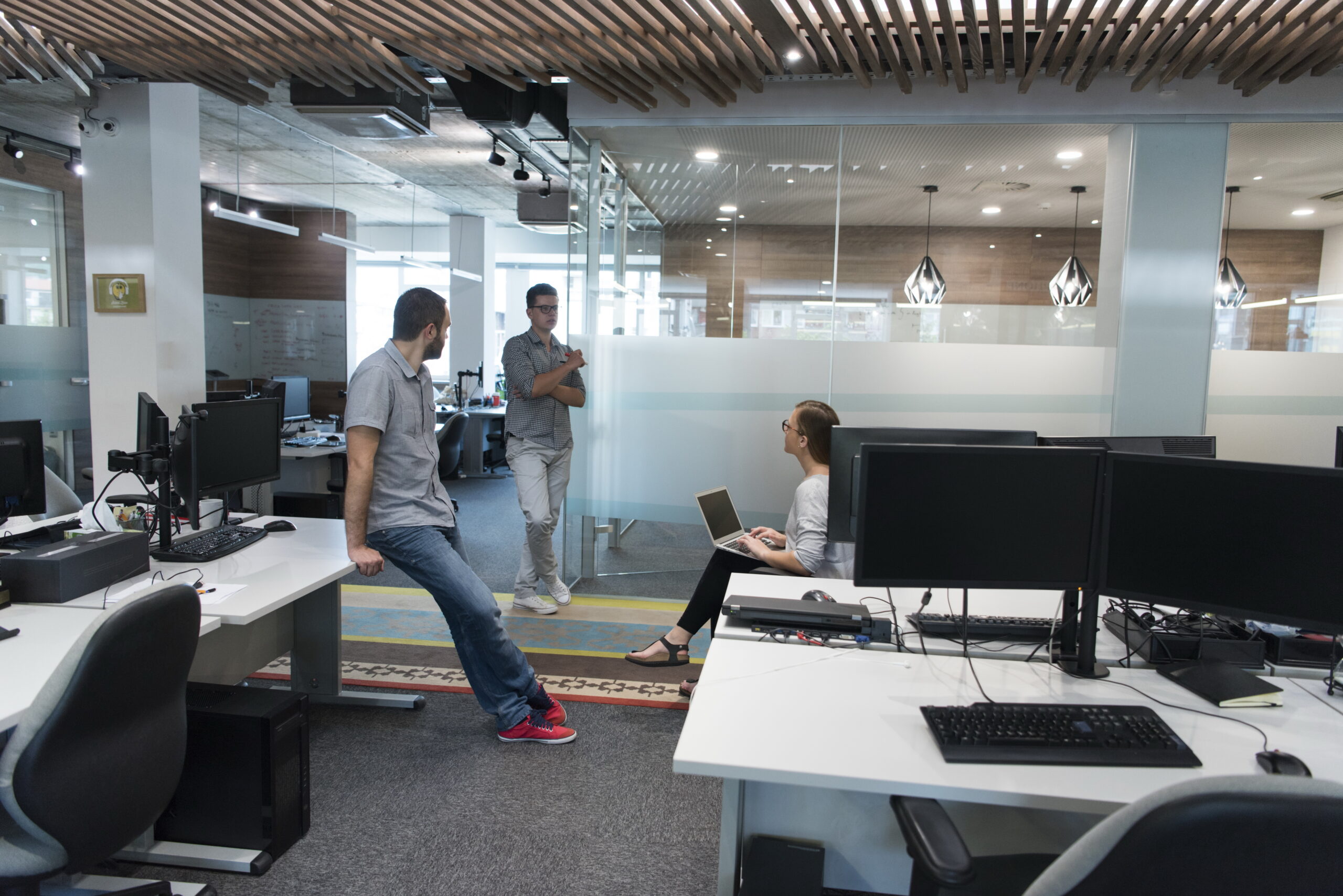 Espace de travail moderne et collaboratif avec une équipe en pleine discussion. Ce bureau ouvert favorise les échanges et la collaboration, créant un environnement dynamique et propice à l'innovation.